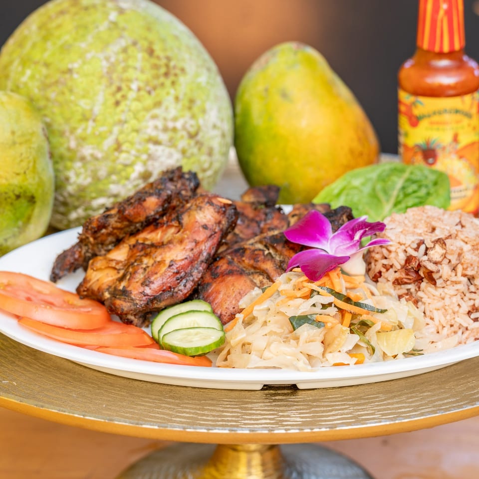 Hazel's Jamaican jerk chicken with rice, vegetables, and a purple orchid garnish.